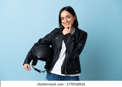 Woman Holding A Motorcycle Helmet Isolated On Blue Background Happy And Smiling