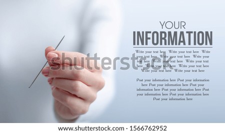 Woman holding needle on gray light background, space for text
