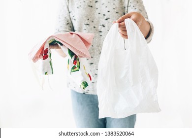 Woman holding in one hand groceries in reusable eco bag and in other vegetables in plastic polyethylene bag. Choose plastic free items. Ban single use plastic. Zero Waste shopping concept. - Shutterstock ID 1383520064
