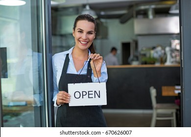 Woman holding open sign in cafe
 - Powered by Shutterstock