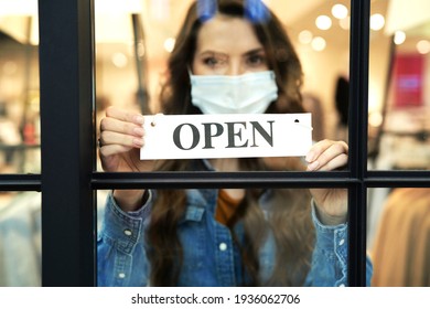 Woman Holding Open Sign In A Small Business Boutique Shop