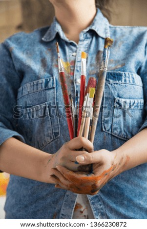 Woman holding paintbrushes. Close Up