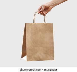 Woman Holding Paper Shopping Bag On Gray Background