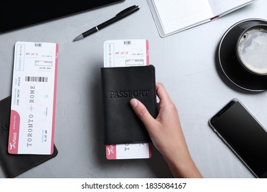 Woman Holding Passport And Ticket At Table, Top View. Travel Agency Concept