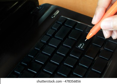 Woman holding pen with laptop pressing enter button, soft focus. - Powered by Shutterstock