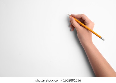 Woman holding pencil on white background, top view - Powered by Shutterstock