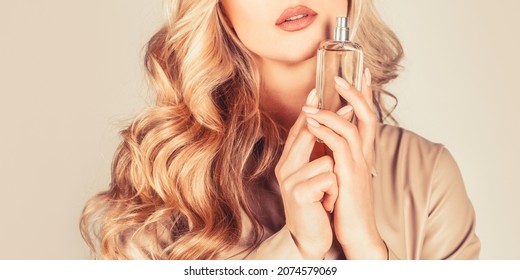 Woman holding a perfumes bottle. Womans with perfum bottle. Beautiful girl using perfume. Woman with bottle of perfume. Woman presents perfumes fragrance.