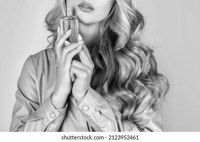 Woman holding a perfumes bottle. Womans with perfum bottle. Beautiful girl using perfume. Woman with bottle of perfume. Woman presents perfumes fragrance. Black and white