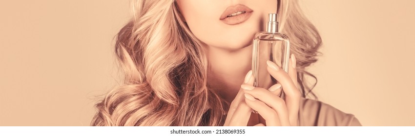 Woman holding a perfumes bottle. Womans with perfum bottle. Beautiful girl using perfume. Woman with bottle of perfume. Woman presents perfumes fragrance.
