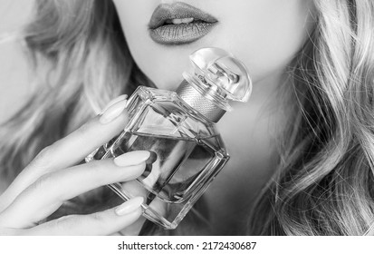 Woman holding a perfumes bottle. Womans with perfum bottle. Beautiful girl using perfume. Woman with bottle of perfume. Woman presents perfumes fragrance. Black and white.