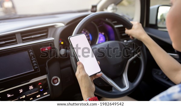 Woman holding a phone with a blank screen while\
driving to work in the\
morning