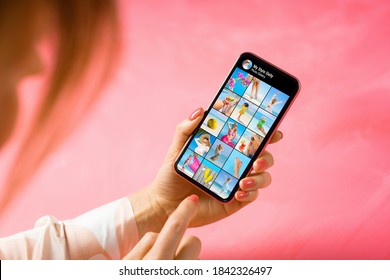 Woman holding phone in hand and browsing looking at other person's photo gallery
