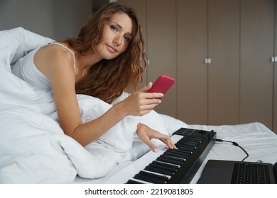 Woman Is Holding Phone In Hand And Playing Musical Instrument