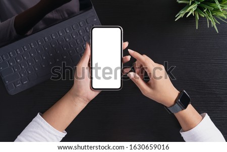 a woman holding phone showing white screen on top view