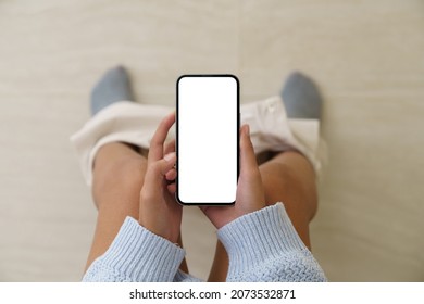 Woman Holding A Phone While Using The Toilet, Mock Up Phone  White Screen Display In Hand