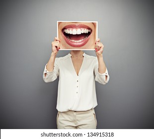 woman holding picture with big smile. concept photo over dark background