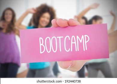 Woman Holding Pink Card Saying Bootcamp Against Fitness Class In Gym