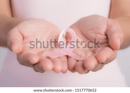 Woman holding a pink ribbon.  Breast cancer awareness month. Health care and medical concept.