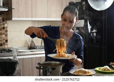 Woman holding a plate of Italian spaghetti making smoke.Pasta dough made from wheat flour