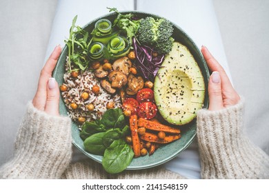Woman holding plate with vegan or vegetarian food. Healthy plant based diet. Healthy dinner or lunch. Buddha bowl with fresh vegetables. Healthy eating