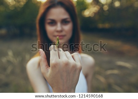 woman holding a praying mantis on the nature                       