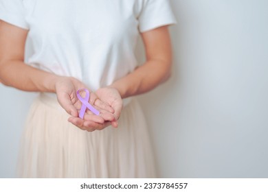 woman holding Purple Ribbon for Stomach, Violence, Pancreatic, Esophageal, Testicular cancer, Alzheimer, epilepsy, lupus, Sarcoidosis and Fibromyalgia. Awareness month and World cancer day concept - Powered by Shutterstock