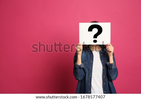 Woman holding question mark sign on pink background. Space for text