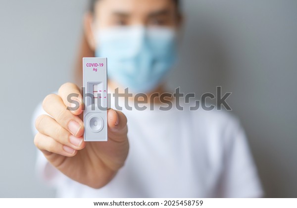 woman holding Rapid Antigen Test\
kit with Positive result during swab COVID-19 testing. Coronavirus\
Self nasal or Home test, Lockdown and Home Isolation\
concept