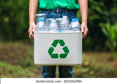 A woman holding a recycle bin with plastic bottles in the outdoors - Shutterstock ID 1815062984