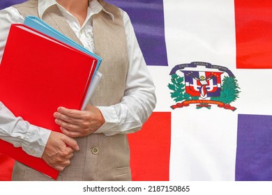 Woman holding red folder on Dominican Republic flag background. Education and jurisprudence concept in Dominican Republic - Shutterstock ID 2187150865