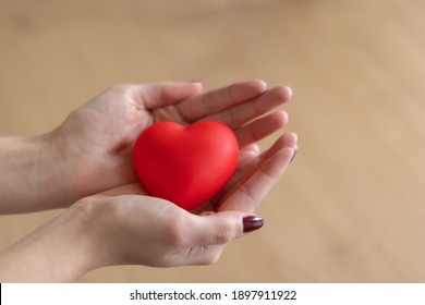 A woman holding a red heart between her hands. Happy valentine’s day, red color, heart icon, isolated background