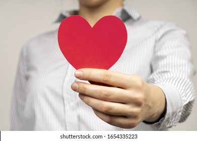 Woman Holding Red Heart In Hand. 
Symbols: Love And Relationships, Medicine And Heart Disease Prevention, Help And Charity.