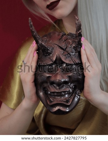 Woman holding red oni mask.