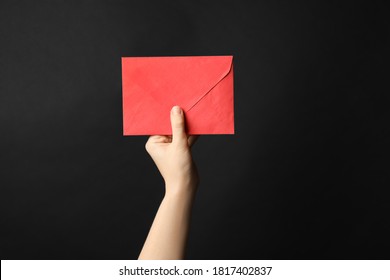 Woman Holding Red Paper Envelope On Black Background, Closeup