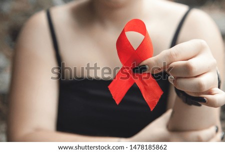 Woman holding red ribbon. Breast cancer