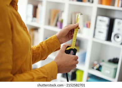 Woman holding a roll meter, she wants to maximize space in her home, DIY and interior design concept - Powered by Shutterstock