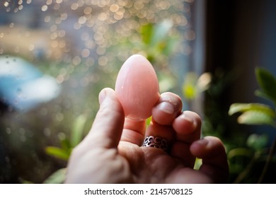 Woman Holding A Rose Quartz Yoni Egg