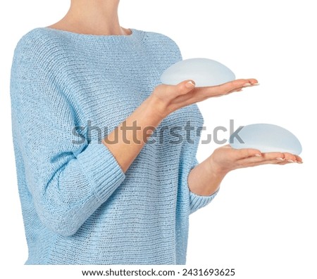 Woman holding round implants on white background with clipping path.