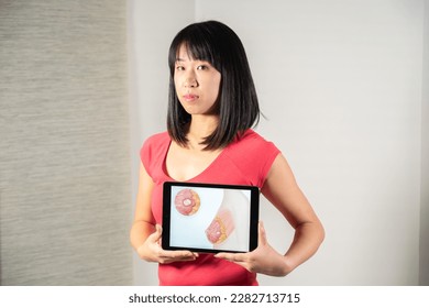 Woman holding screen with drawing of breast cancer - Shutterstock ID 2282713715