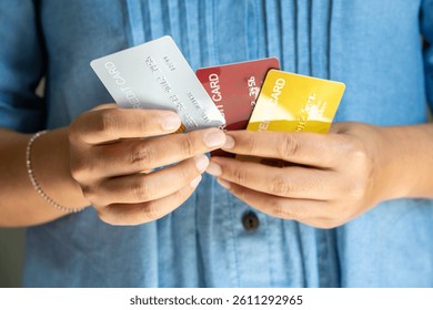 woman holding several credit cards and he is choosing a credit card to pay and spend Payment for goods via credit card. Finance and banking concept.