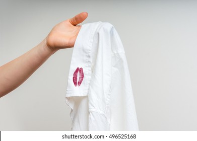 Woman Holding A Shirt With Red Kiss Lipstick Of Her Unfaithful Husband