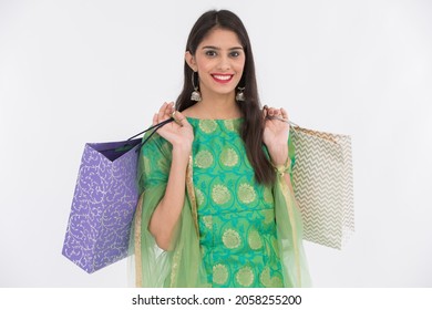 Woman holding shopping bags on white background.