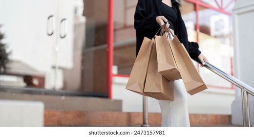 Woman Holding Shopping Bags on Black Friday. Urban Shopping Scene with Brown Paper Bags Retail, Sale, and Consumerism Concept