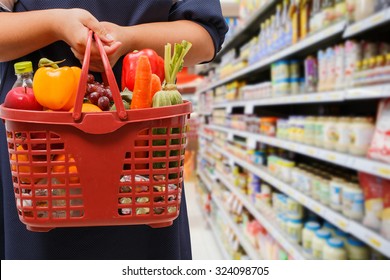 Woman Holding Shopping Basket In Grocery Store