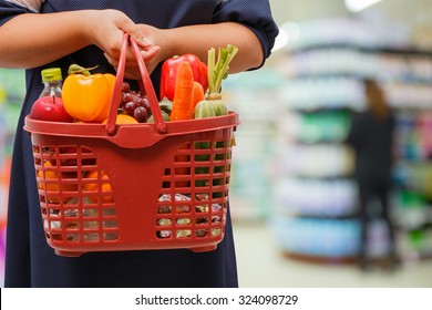 Woman Holding Shopping Basket In Grocery Store