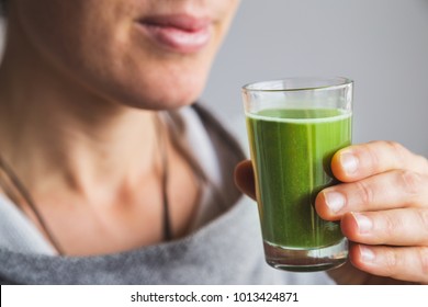 Woman Holding Shot Of Wheatgrass Juice