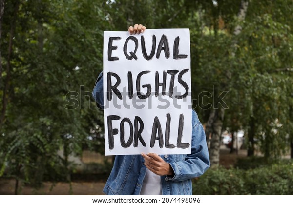 Woman holding sign with text Equal rights for\
all outdoors