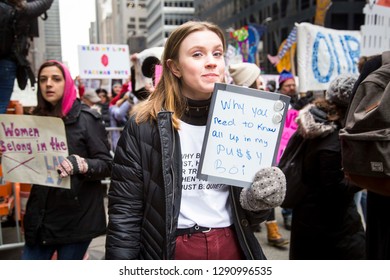 Woman Holding Up A Sign Walking Amongst A Crowd Of People During The NYC Women's March - New York, NY, USA January 1/19/2019 Women's March