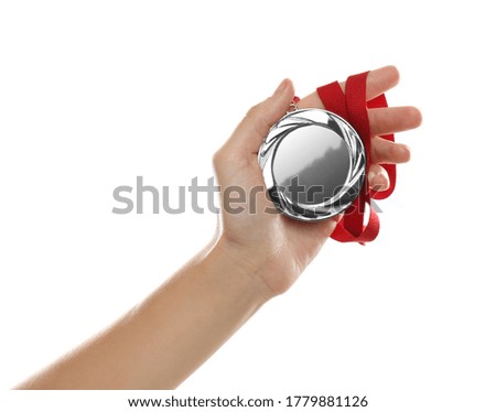 Woman holding silver medal on white background, closeup. Space for design