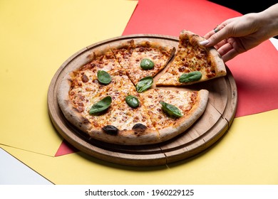 A Woman Is Holding A Slice Of Pizza, Hand Only Visible